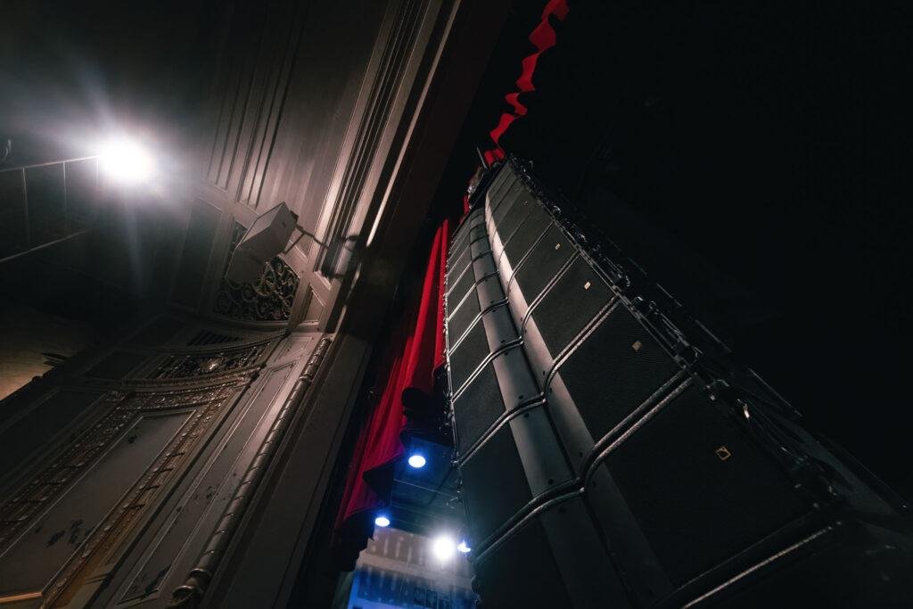 speakers hanging from ceiling in concert venue