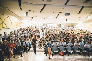 Group of people sitting looking at a screen during a live stream conference put together with the Live Streaming Services from Harmonic Production
